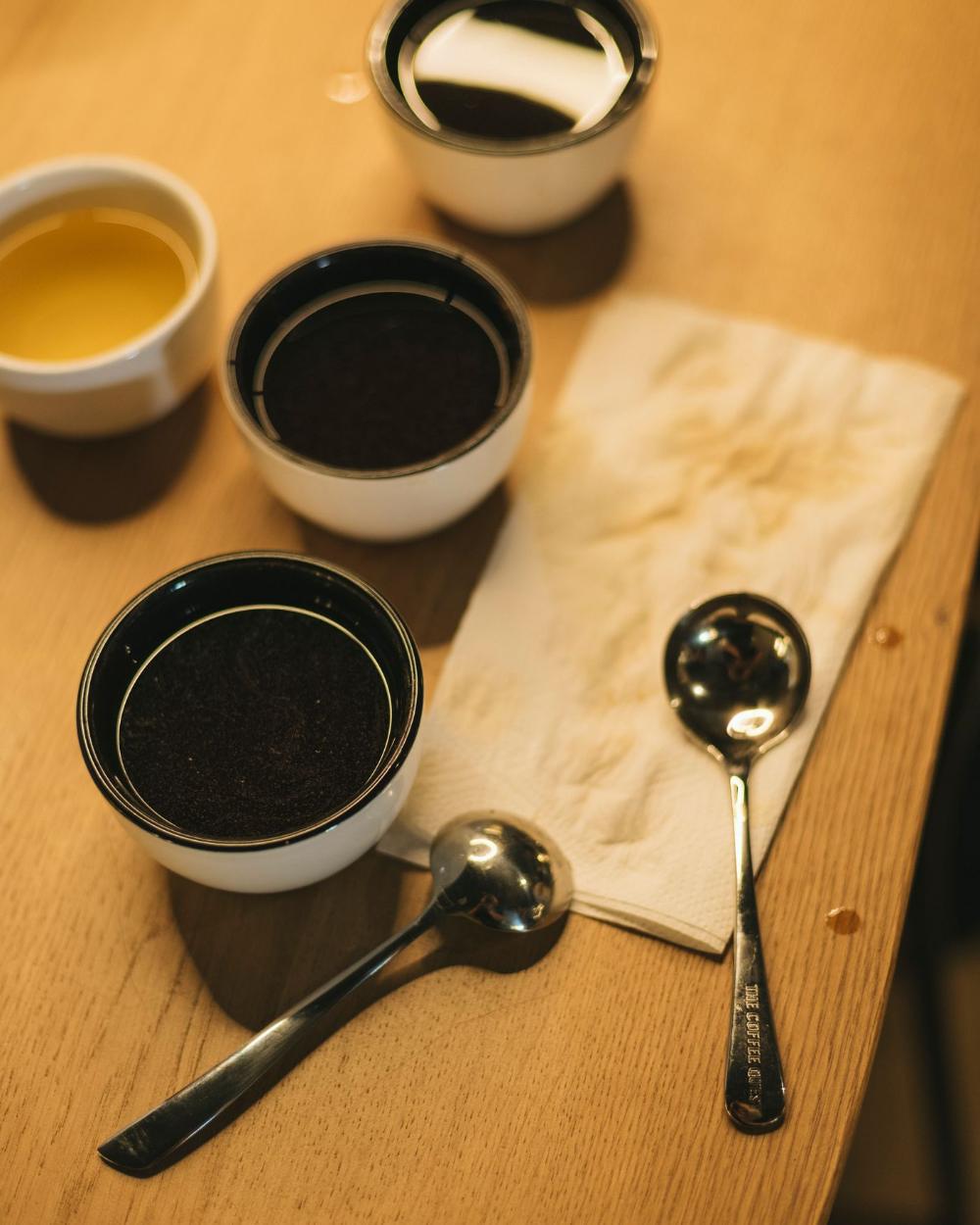 Coded tasting cups and spoons laid out for evaluation